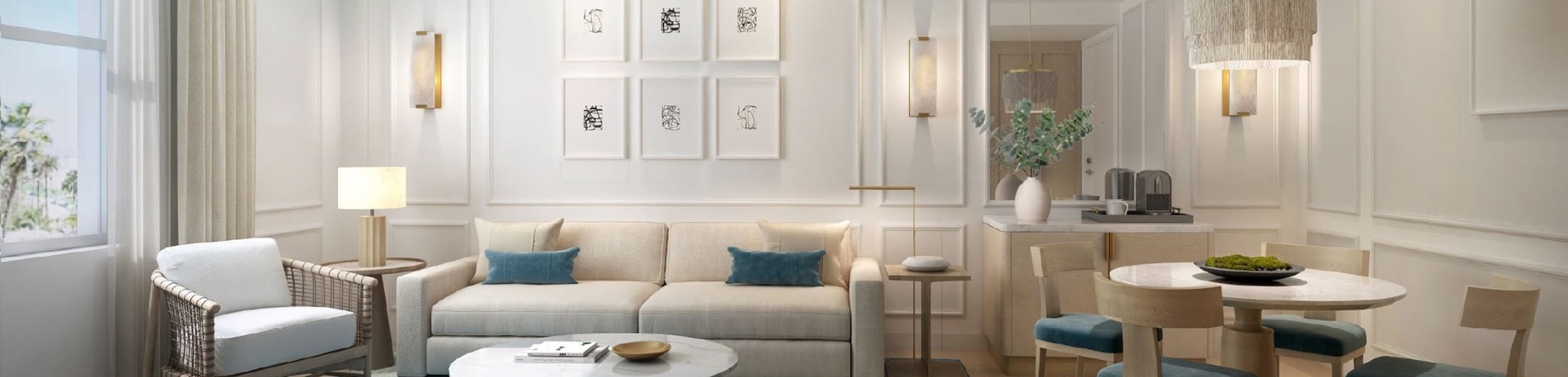 The living area of the Guest Room Suite, including small dining table, couch chair, carpet and soft white light at Fairmont Breakers in Long Beach, CA.