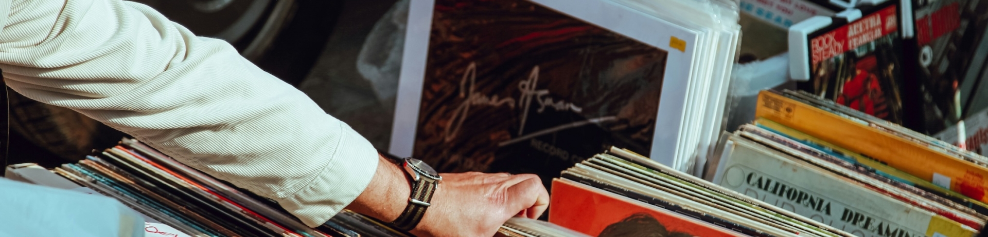 A man looks through a stack of vinyl records for sale.