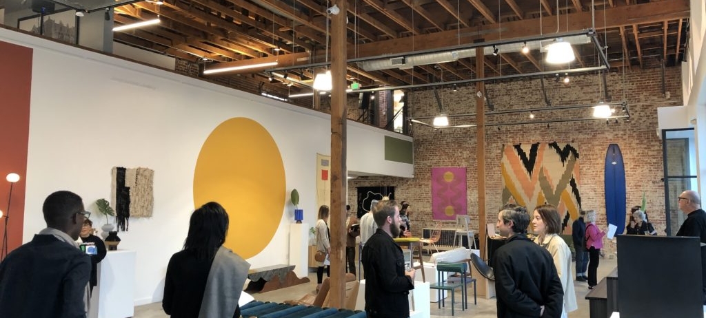 An art gallery exhibit opening in a modern building.
