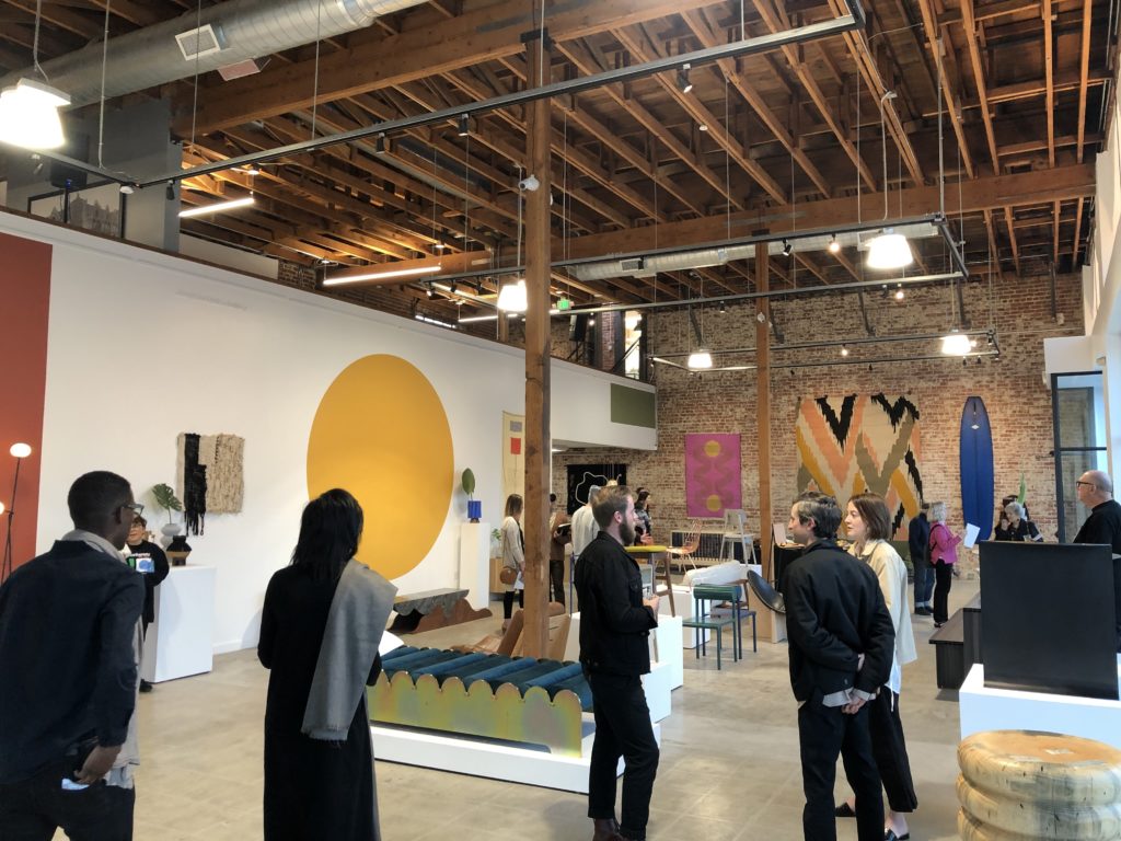 An art gallery exhibit opening in a modern building.